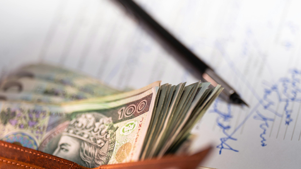 Notas de dinheiro e caneta representando alíquotas do imposto de renda aplicadas ao empreendedorismo online.