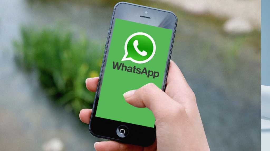 Pessoa segurando smartphone com logotipo do WhatsApp representando principal canal de vendas digitais