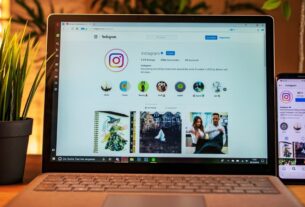 Notebook aberto exibindo um perfil do Instagram com foco na aba de Reels, ao lado de um smartphone mostrando a mesma interface.